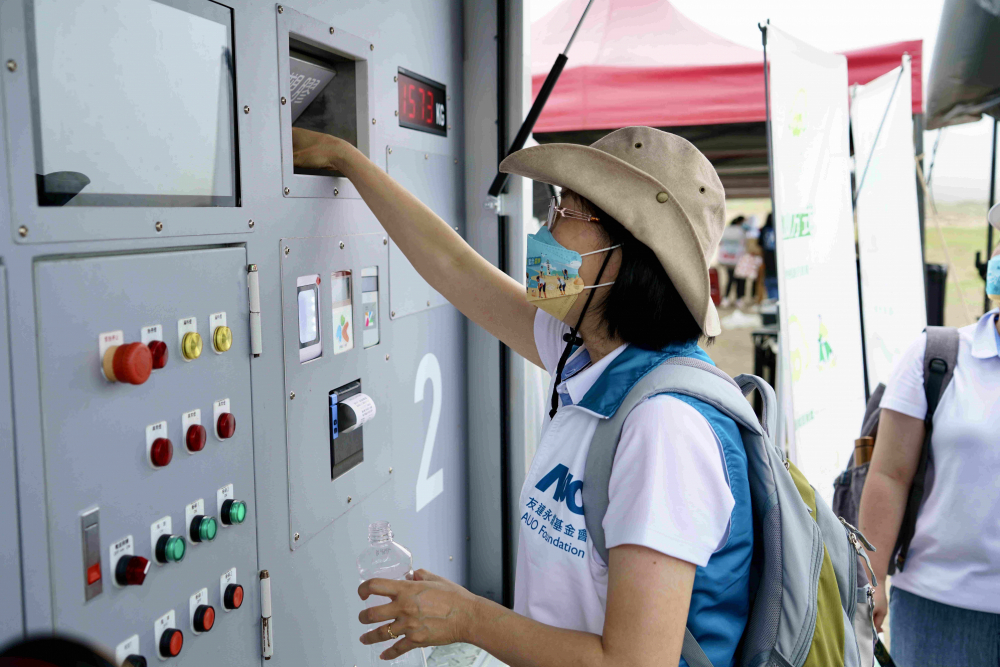 志工們將拾起的寶特瓶投入「好歸塑專車」，讓廢棄塑料空瓶可以直接粉碎、縮小體積，未來將可再製成購物袋、寶特衣、悠遊卡等生活用品